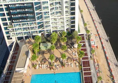 an aerial view of a building with a pool at Modern Living DAMAC with Balcony & Waterfront Views in Dubai
