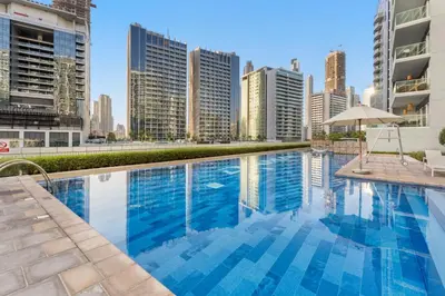 a swimming pool in a city with tall buildings at Cozy 1 BR in the Center - 5 mins to Burj Khalifa in Dubai
