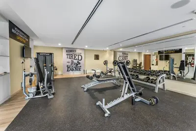 a gym with several tread machines and a mirror at Cozy 1 BR in the Center - 5 mins to Burj Khalifa in Dubai