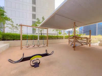 a playground with swings and a monkey bars at Cozy 1 BR in the Center - 5 mins to Burj Khalifa in Dubai