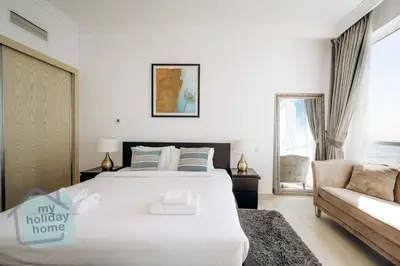a bedroom with a large white bed and a couch at Private Beach - Tourist Spot - High Floor Residence in Dubai