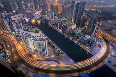 a city at night with a river and buildings at Private Beach - Tourist Spot - High Floor Residence in Dubai