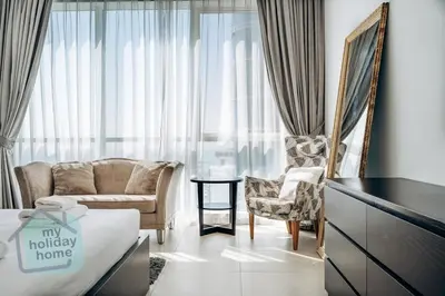 a hotel room with a bed and a couch and a chair at Private Beach - Tourist Spot - High Floor Residence in Dubai
