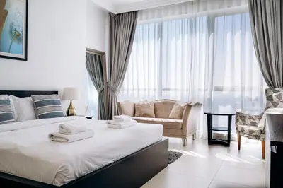 a white bedroom with a bed and a couch at Private Beach - Tourist Spot - High Floor Residence in Dubai