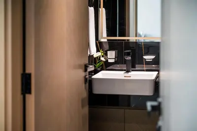 a bathroom with a white sink and a mirror at Brand New Luxurious - Modern 1BR - Pool - Gym in Dubai