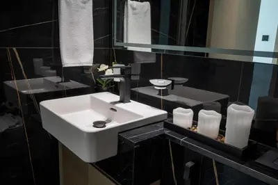 a bathroom with a white sink and a mirror at Brand New Luxurious - Modern 1BR - Pool - Gym in Dubai