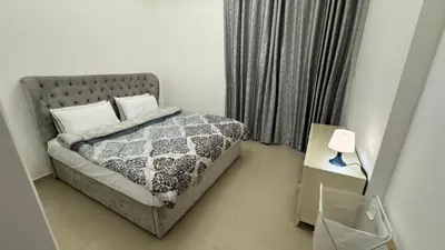 a bedroom with a bed and a table with a lamp at 2BHK Garden Apartment at the heart of Dubai Marina in Dubai