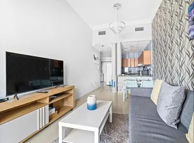 a living room with a couch and a tv at 1 Bedroom in Dubai Marina opp Dmcc metro station in Dubai