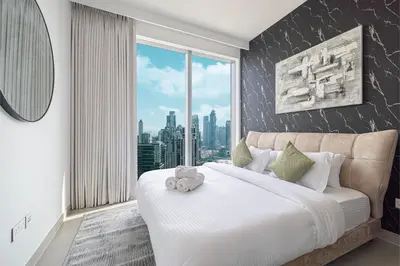 a bedroom with a large bed with a large window at Stunning Downtown 4BR Sky High Luxury Apartment with Fountain Views in Dubai