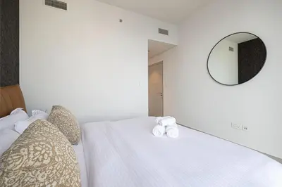 a bedroom with a white bed with a mirror at Stunning Downtown 4BR Sky High Luxury Apartment with Fountain Views in Dubai