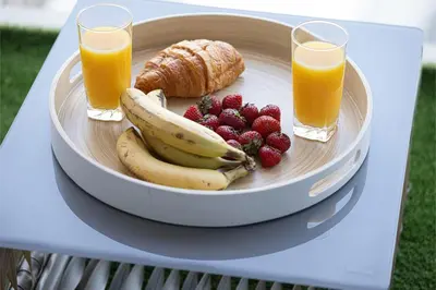 a plate of fruit with two glasses of orange juice at Stunning Downtown 4BR Sky High Luxury Apartment with Fountain Views in Dubai