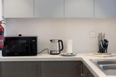 a kitchen counter with a microwave and a sink at Stunning Downtown 4BR Sky High Luxury Apartment with Fountain Views in Dubai