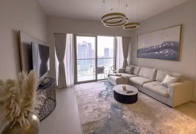 a living room with a couch and a large window at GRANDE SIGNATURE with a direct Burj Khalifa view and Private Fountain Show at high floor with DXB AIRPORT VIP Shuttle option for 6 guests in Dubai