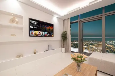 a living room with a large window and a tv at 3BR in Paramount with Panoramic Infinity Pool in Dubai