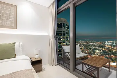 a bedroom with a view of a city at 3BR in Paramount with Panoramic Infinity Pool in Dubai
