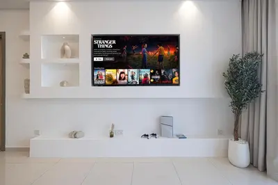 a living room with a tv on the wall at 3BR in Paramount with Panoramic Infinity Pool in Dubai