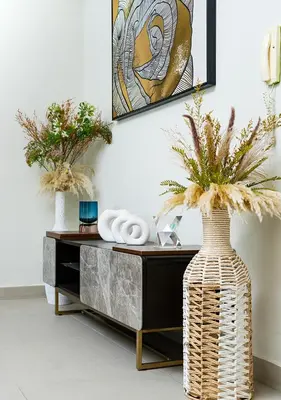 a living room with a vase with flowers in it at 2BR Apartment In Dubai in JVC near Circle mall in Dubai