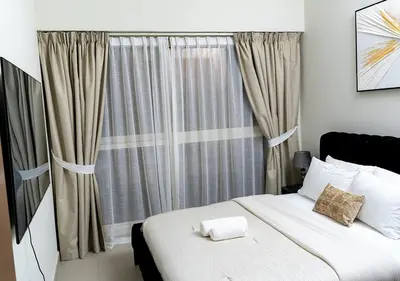 a bedroom with a bed and a large window at 2BR Apartment In Dubai in JVC near Circle mall in Dubai