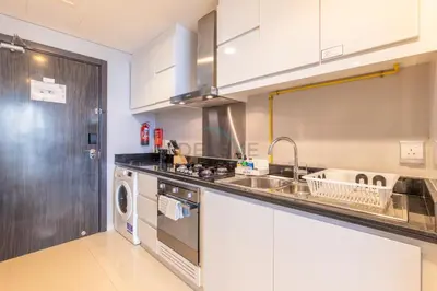 a kitchen with a sink and a dishwasher at High-Rise Studio Near the Golf Club and Mall with a Community View,Damac Hills Artesia Tower D, Dubailand by Deluxe Holiday Homes in Dubai
