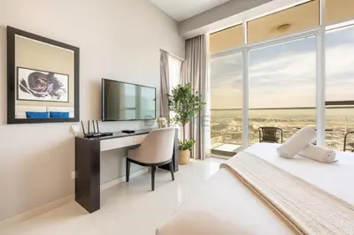 a bedroom with a bed and a desk with a television at High-Rise Studio Near the Golf Club and Mall with a Community View,Damac Hills Artesia Tower D, Dubailand by Deluxe Holiday Homes in Dubai