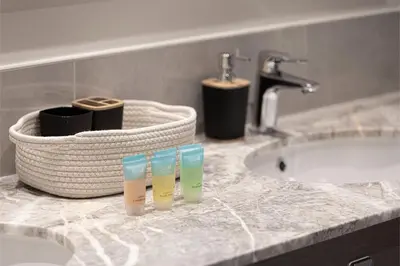 a bathroom counter with a sink and a bath tub at Stay in Modern Elegance 4BR with Pool Gym and Boulevard Views in Dubai