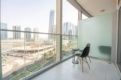 a chair sitting in a room with a large window at Bnbeyond's Artsy Canal-View Studio in the Heart of BBay in Dubai