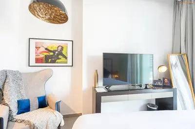 a living room with a tv and a chair at Bnbeyond's Artsy Canal-View Studio in the Heart of BBay in Dubai
