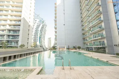 a swimming pool in the middle of two tall buildings at Bnbeyond's Artsy Canal-View Studio in the Heart of BBay in Dubai