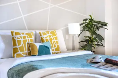 a bedroom with a bed with pillows and a plant at The Smart Concierge - Rimal 4 in Dubai