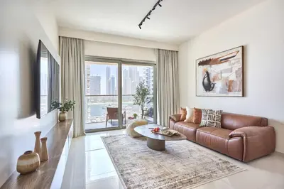 a living room with a brown leather couch and a table at Frank Porter - Grand Bleu Tower 2 in Dubai