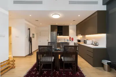 a kitchen with a table and chairs in a room at La Sirene 1, Port De La Mer - Mint Stay in Dubai
