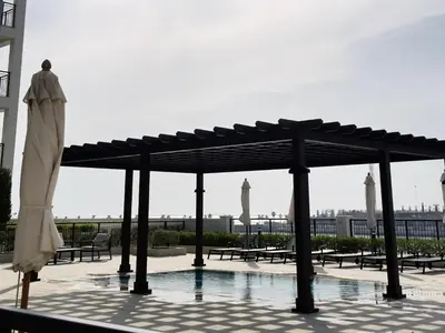 a pavilion with tables and chairs and a pool at La Sirene 1, Port De La Mer - Mint Stay in Dubai