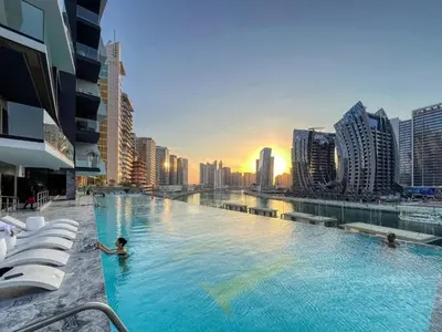 a swimming pool with a city skyline in the background at The Smart Concierge - Binghatti Canal in Dubai