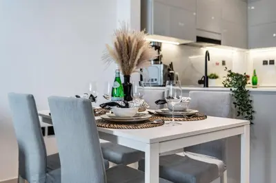 a dining room table with chairs and wine bottles on it at The Smart Concierge - Binghatti Canal in Dubai