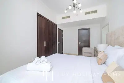 a bedroom with a white bed with two towels at LUX The Dubai Marina View Suite 2 in Dubai