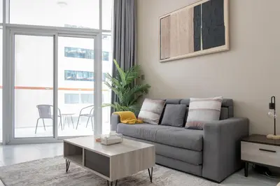 a living room with a couch and a table at Urban Living with Balcony, Pool, and Quick Access to Burj Khalifa in Dubai