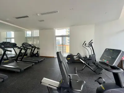 a gym with several treadmills and exercise bikes at Urban Living with Balcony, Pool, and Quick Access to Burj Khalifa in Dubai