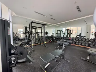 a gym with several rows of equipment in a room at Urban Living with Balcony, Pool, and Quick Access to Burj Khalifa in Dubai