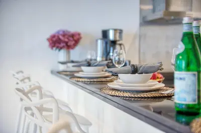 a counter with plates and wine glasses on it at The Smart Concierge - Damac Heights in Dubai