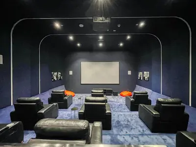 a theater room with couches and a white screen at The Smart Concierge - Damac Heights in Dubai