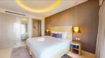 a large bedroom with a large white bed and a ceiling at Moderne 1BR apartment overlooking city in Dubai