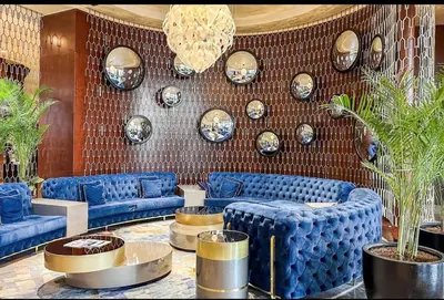 a lobby with blue couches and plates on a wall at Moderne 1BR apartment overlooking city in Dubai