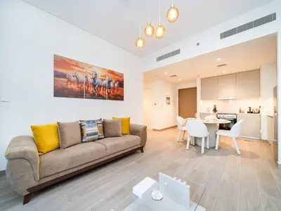 a living room with a couch and a dining room at Modern 1-Bed Escape with Large Terrace, Creek Beach Dubai in Dubai