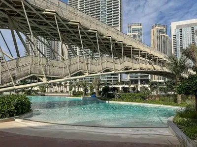 a bridge over a swimming pool in a city at Modern 1-Bed Escape with Large Terrace, Creek Beach Dubai in Dubai