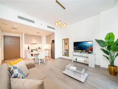 a living room with a couch and a table with a tv at Modern 1-Bed Escape with Large Terrace, Creek Beach Dubai in Dubai