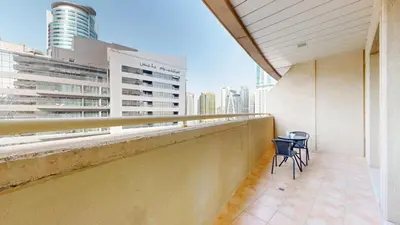 a balcony with two chairs and a table on a building at Vacationer I Premium 1 Bed I Dubai Marina Living & Metro Nearby I Dream Tower in Dubai