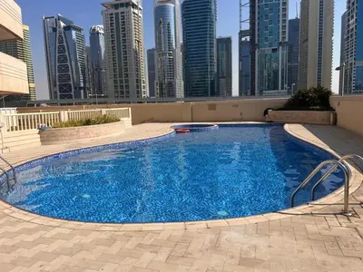 a large swimming pool in a city with tall buildings at Vacationer I Premium 1 Bed I Dubai Marina Living & Metro Nearby I Dream Tower in Dubai