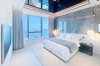 a bedroom with a large bed and a large window at Palm Tower - Luxurious One Bed with Palm View in Dubai