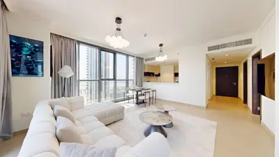 a living room with a white couch and a table at Creek Residences - One Bedroom with Creek View in Dubai