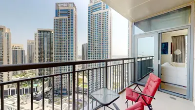 a balcony with red chairs and a view of the city at Creek Residences - One Bedroom with Creek View in Dubai